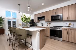 Woodinville apartment for rent - A modern kitchen with wooden cabinets and a white island.