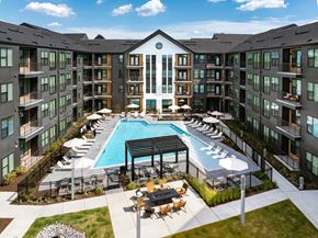 Nashville apartment for rent - an outdoor pool with lounge chairs and tables in front of an apartment building