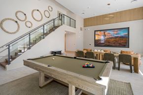 Phoenix apartment for rent - A pool table is in the middle of a room with a staircase and a painting on the wall.