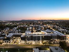 Nashville apartment for rent - A cityscape at dusk with a large building in the foreground.
