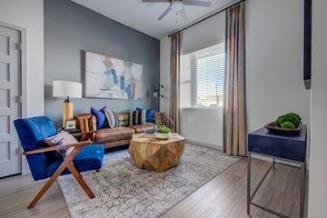 Salt Lake City apartment for rent - A living room with a blue chair and a wooden coffee table.