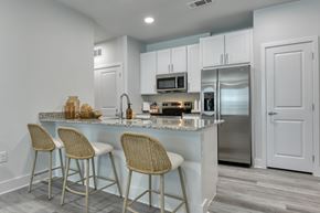 San Antonio apartment for rent - A kitchen with a white counter and bar stools.