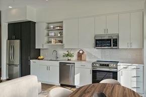 Richmond apartment for rent - A modern kitchen with white cabinets and a wooden island.