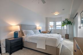 Seattle apartment for rent - A bedroom with a large bed and a ceiling fan.