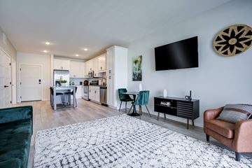 Shakopee apartment for rent - a living room with a couch and a tv and a kitchen