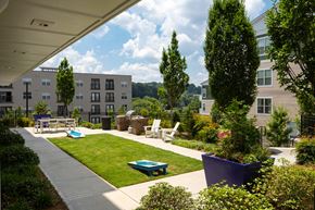 Atlanta apartment for rent - A sunny day at a residential complex with a pool and a playground.