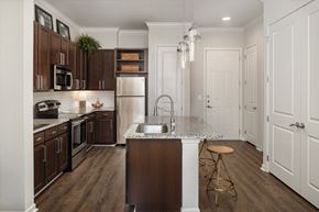 Atlanta apartment for rent - A kitchen with brown cabinets and a white counter.