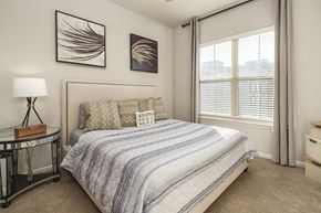 Atlanta apartment for rent - A bedroom with a bed, nightstand, and two framed pictures on the wall.