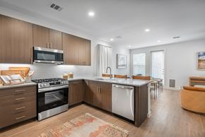 Mckinney apartment for rent - A modern kitchen with wooden cabinets and stainless steel appliances.