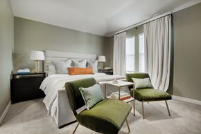 Mckinney apartment for rent - A bedroom with a bed, nightstand, chair, and window.