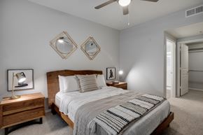Avondale apartment for rent - A bedroom with a bed, nightstand, and two mirrors on the wall.
