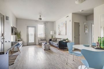Farmington apartment for rent - a living room with a couch and a dining room table