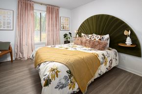 Sandy Springs apartment for rent - a bedroom with a bed with a green headboard