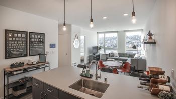 A modern kitchen with a large island and pendant lights.
