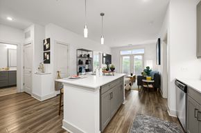 Charlotte apartment for rent - A modern kitchen with white cabinets and a wooden floor.