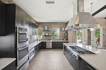 Great room with social areas, full kitchen, large stone fireplace