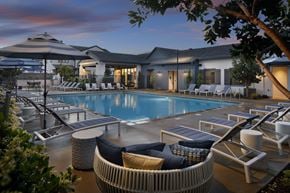 Lathrop apartment for rent - A poolside area with lounge chairs and a sunbed.