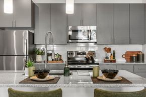 Phoenix apartment for rent - A modern kitchen with a stainless steel refrigerator and a center island with two bowls on top.