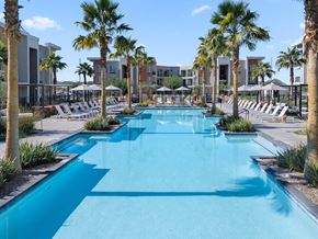 Phoenix apartment for rent - A long rectangular pool surrounded by palm trees and lounge chairs.