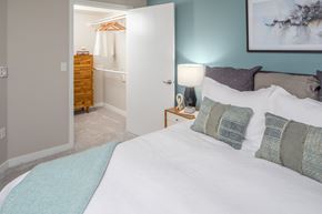 Tualatin apartment for rent - a bedroom with a large bed and a bathroom in the background