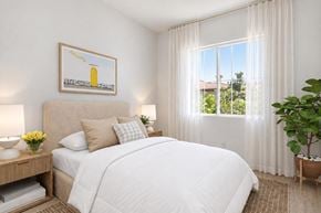 San Diego apartment for rent - A bedroom with a large bed, a painting on the wall, and a potted plant.