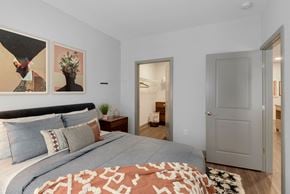 Washington apartment for rent - a bedroom with a large bed and a door to a bathroom