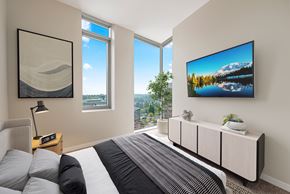 Bellevue apartment for rent - A bedroom with a large bed and a TV mounted on the wall.