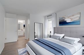 Vista apartment for rent - A bedroom with a large bed and a painting on the wall.