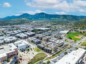 Boulder apartment for rent - A cityscape with buildings and a mountain in the background.