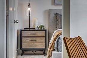 Clearfield apartment for rent - Close up of wood tone night stand, small plant, vase, and lamp through a  doorway at Bravada 193, Clearfield, 84015
