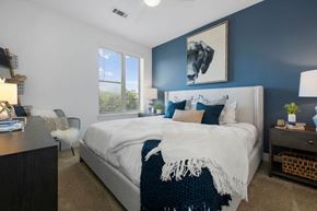 Charlotte apartment for rent - bedroom with blue accent wall and white bed with white blanket and pillows