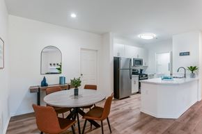 San Diego apartment for rent - A kitchen with a table and chairs in the foreground and a refrigerator in the background.