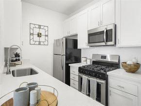 Paramount apartment for rent - a kitchen with a stove top oven next to a sink at Enclave, California