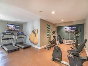Whittier apartment for rent - a home gym with cardio equipment and guitars on the wall at Citrus Court Apartments, Whittier, 90606