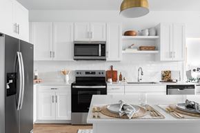 Austin apartment for rent - A modern kitchen with white cabinets and stainless steel appliances.
