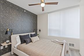 Seattle apartment for rent - a bedroom with a dark accent wall and a ceiling fan