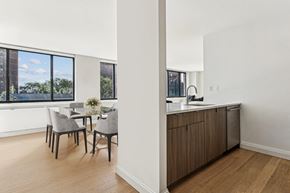 New York apartment for rent - an open kitchen and dining area with a large window and a table and chairs