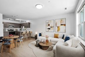 Beverly apartment for rent - A modern living room with a dining area and kitchen in the background.