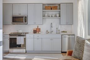 Salt Lake City apartment for rent - a kitchen with white cabinets and a stove and a microwave