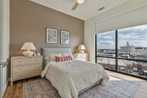 Richmond apartment for rent - A bedroom with a large bed and a view of the city.