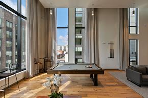 Richmond apartment for rent - A pool table is in the middle of a room with a view of the city.