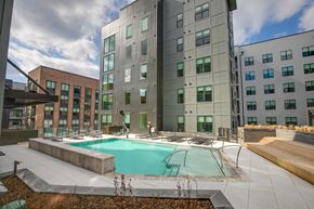 Richmond apartment for rent - A large building with a pool in front.
