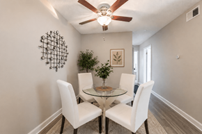 Carrboro apartment for rent - A dining room with a glass table and white chairs.