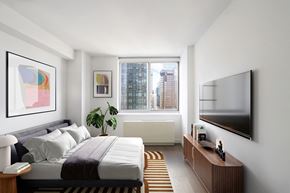 New York apartment for rent - a bedroom with a bed and a television on the wall