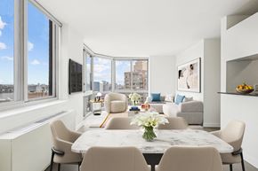 New York apartment for rent - a living room with a large window and a table with chairs
