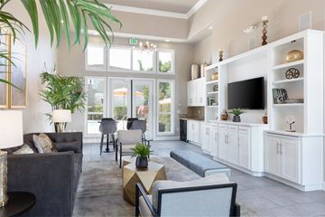 Pleasanton apartment for rent - A living room with a grey couch and a white cabinet with a TV on it.