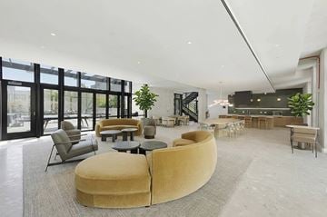 San Francisco apartment for rent - A modern living room with a large yellow circular sofa and a dining area in the background.