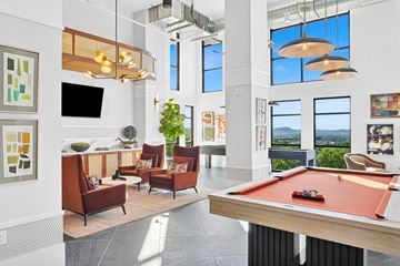 Brentwood apartment for rent - A pool table is in the middle of a room with a television, couches, and pictures on the wall.
