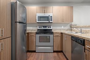 Phoenix apartment for rent - A kitchen with a refrigerator, oven, microwave, and dishwasher.