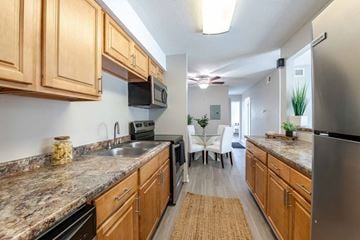 Carrboro apartment for rent - A kitchen with wooden cabinets and granite countertops.